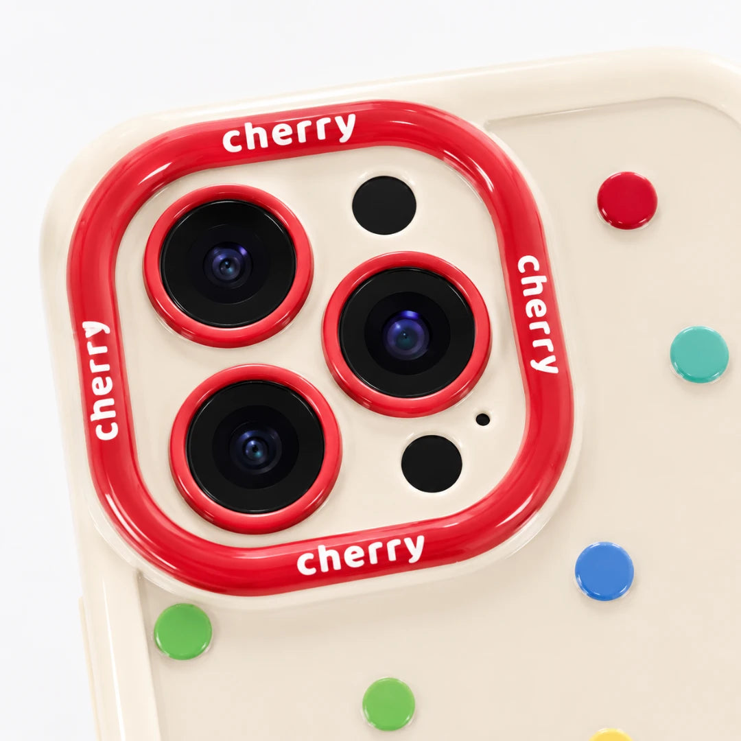 Josh & Tate - CherryPop™ iPhone Case - A close-up of a phone case featuring a red camera ring with 'cherry' text and colorful polka dots on a cream background.