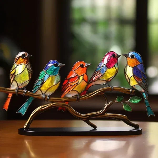 Colorful stained glass birds on a branch with a blurred background
