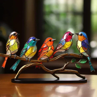 Colorful stained glass birds on a branch with a blurred background