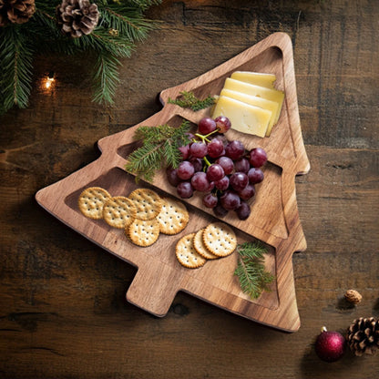 Josh & Tate - Christmas Tree Serving Board - Wooden Christmas tree-shaped cutting board with cheese, crackers, and grapes on a wooden surface.