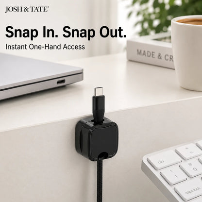 Josh & Tate - ClipCube™ Magnetic Cable Organizer - Black USB adapter on a desk with laptop, keyboard, and coffee cup in the background.