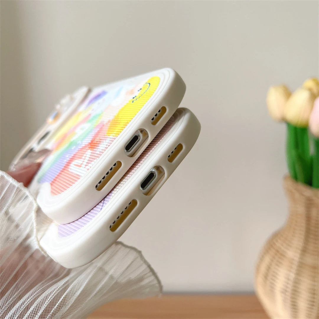 Josh & Tate - CloudPop™ Sliding Lens iPhone Case - Phone case with colorful design held by a hand, blurred background