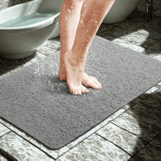 Person stepping onto a textured bath mat in a bathroom setting