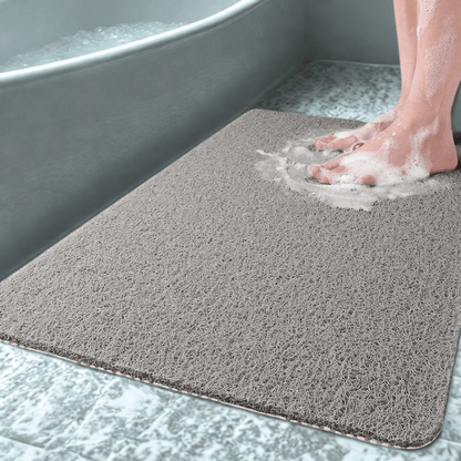 Gray bath mat with soapy water on a bathroom floor