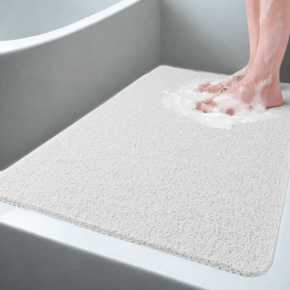 Person stepping onto a bath mat with soapy feet in a bathtub