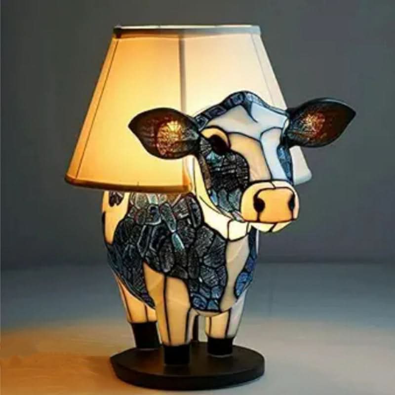 Cow-shaped lamp with a beige shade on a dark background