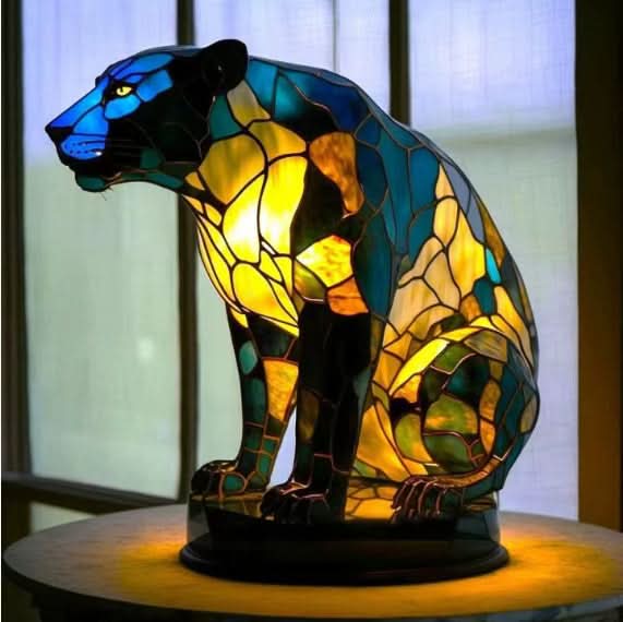 Stained glass panther lamp on a wooden surface with a blurred background