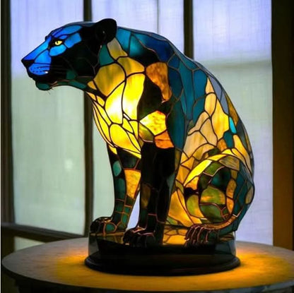 Stained glass panther lamp on a wooden surface with a blurred background