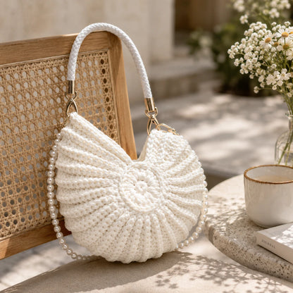 Josh & Tate - ConchKnit™ Pearl Handbag - White beaded handbag on a table with a blurred background