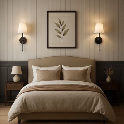 Neatly made bed with beige bedding in a bedroom setting with wall art and lamps.