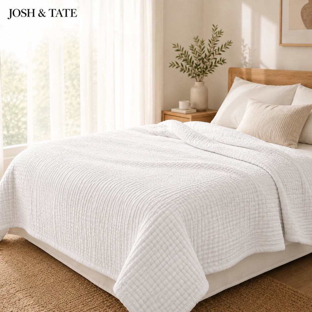Josh & Tate - CottonFold™ Thick Air Conditioner Blanket - Bed with white bedding and pillows in a bright bedroom setting, featuring the brand 'Josh & Tate'.