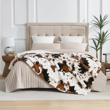 Bed with cow print blanket and beige headboard in a room setting