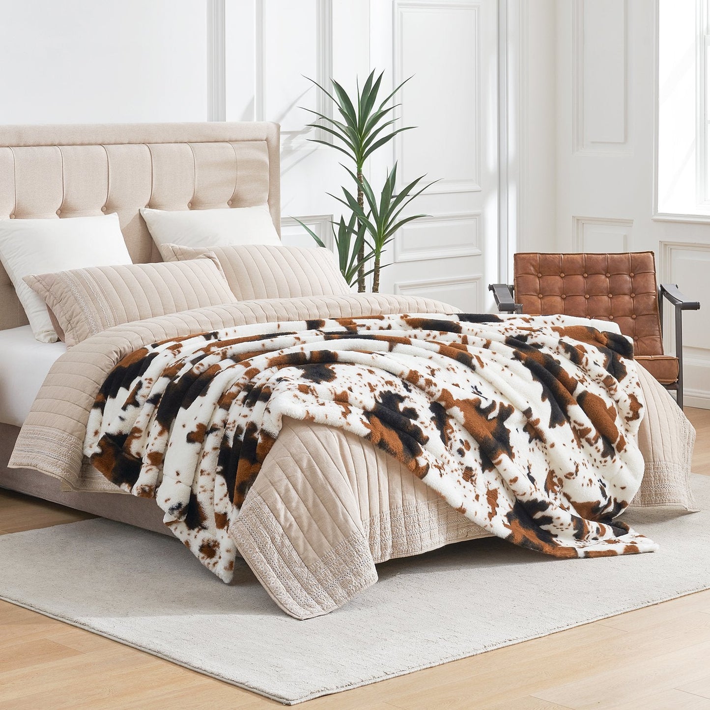 Bed with cow print comforter in a bright bedroom setting