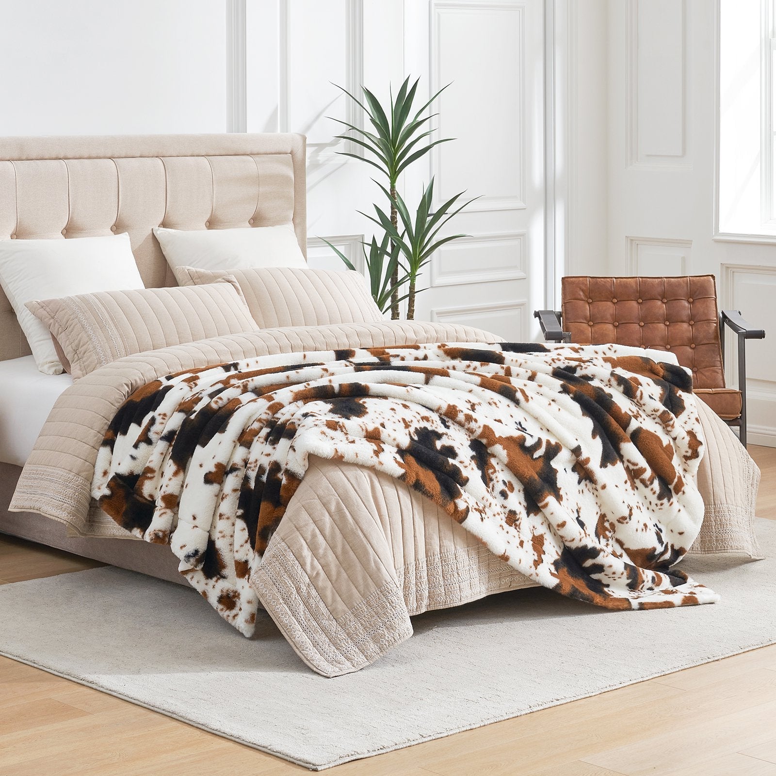 Bed with cow print comforter in a bright bedroom setting