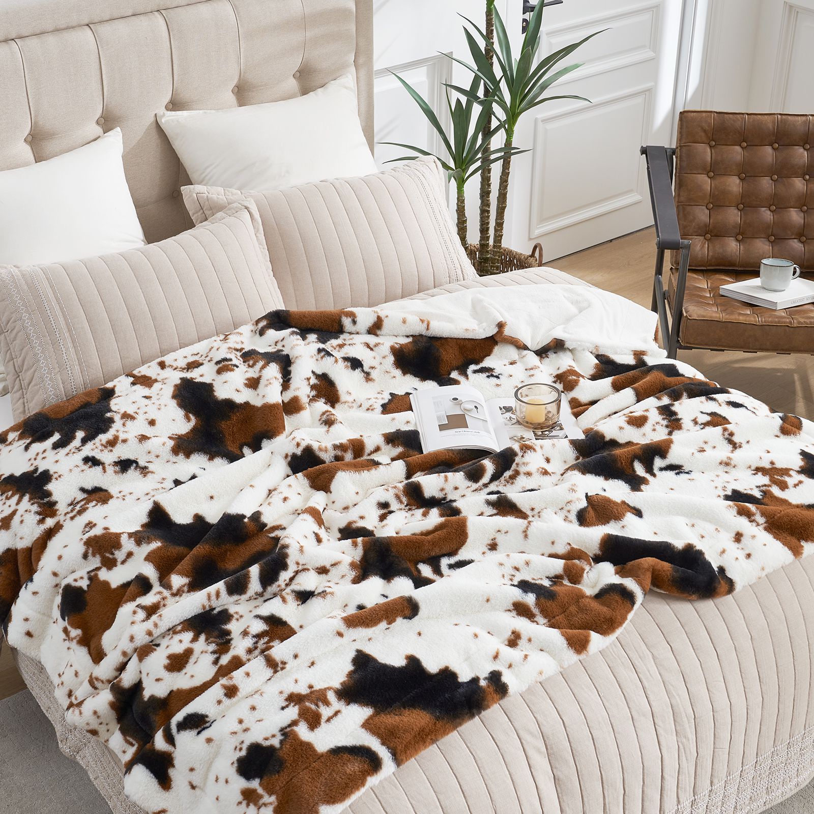 Cow print blanket on a bed in a bedroom setting