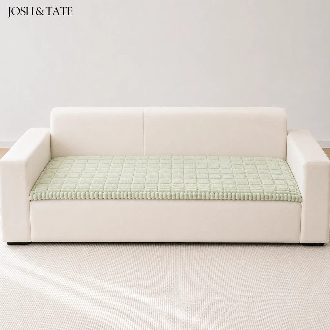 Josh & Tate - CozyLayer™ Plush Sofa Protector - White sofa with a green textured cushion on a light gray background, featuring the brand 'Josh & Tate'.