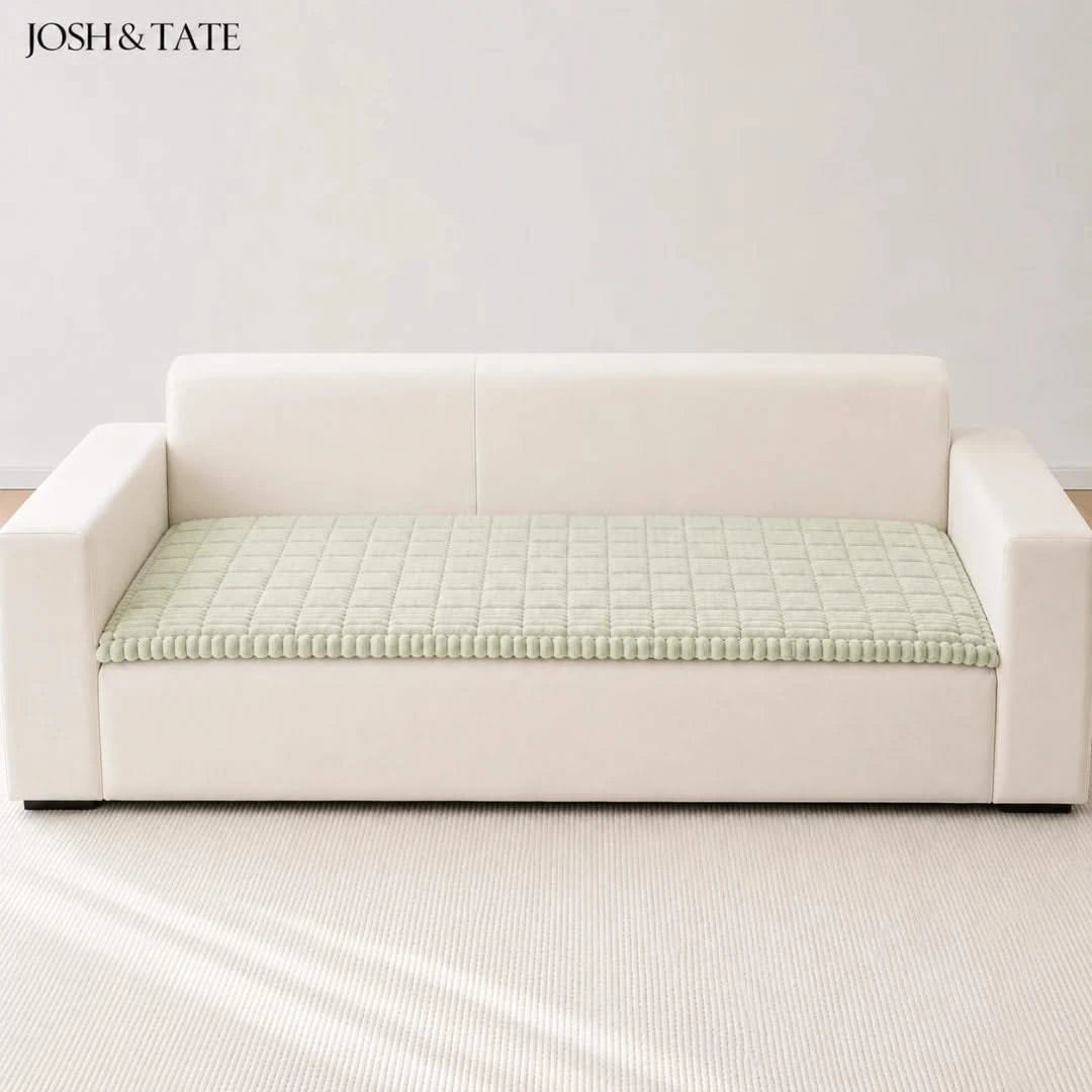 Josh & Tate - CozyLayer™ Plush Sofa Protector - White sofa with a green textured cushion on a light gray background, featuring the brand 'Josh & Tate'.