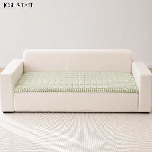 Josh & Tate - CozyLayer™ Plush Sofa Protector - White sofa with a green textured cushion on a light gray background, featuring the brand 'Josh & Tate'.