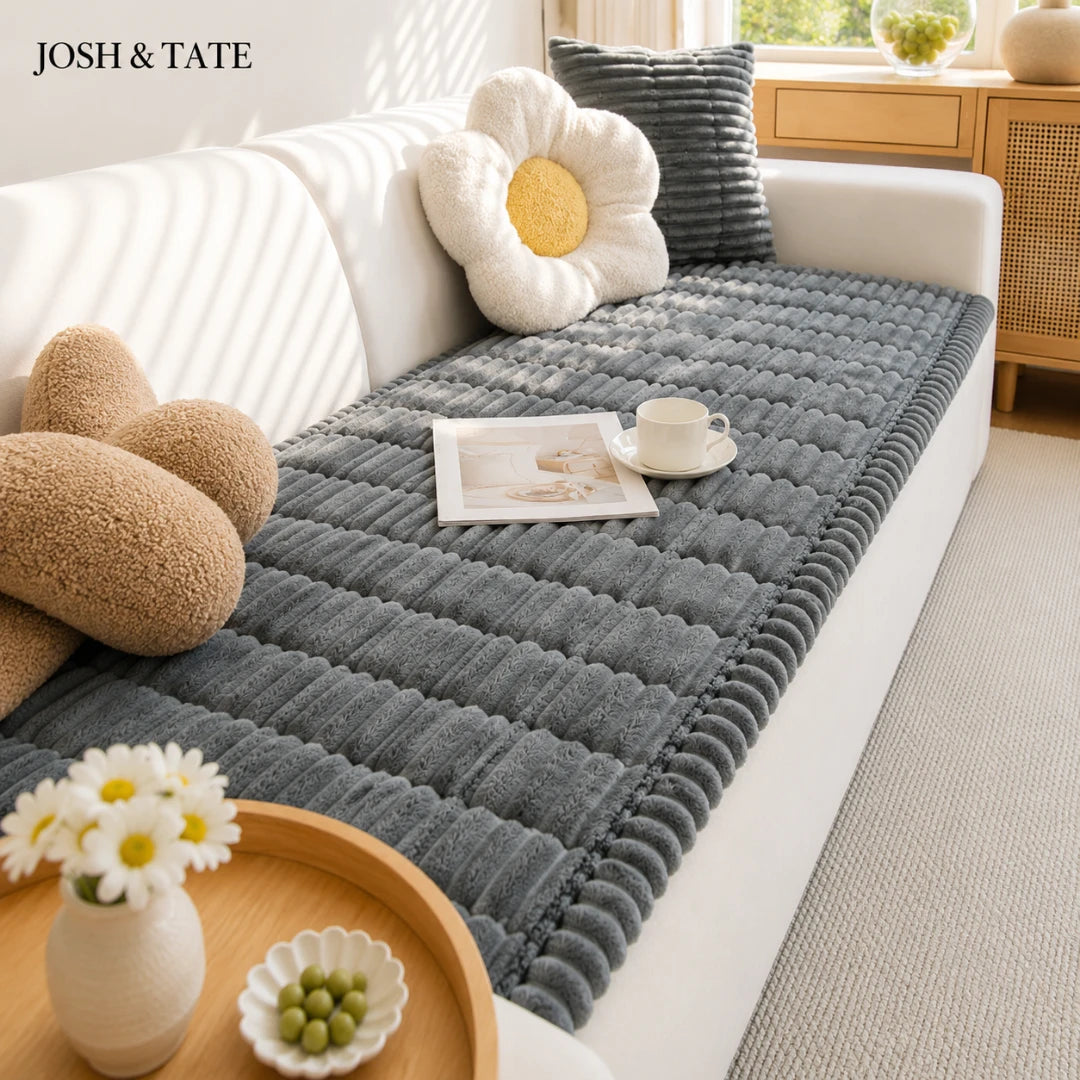 Josg & Tate - CozyLayer™ Plush Sofa Protector - Gray textured sofa cover on a white sofa with decorative pillows and a small table.