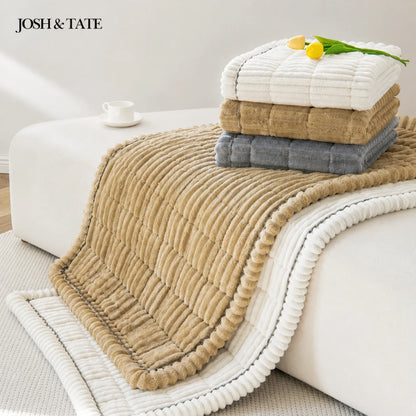 Josh & Tate - CozyLayer™ Plush Sofa Protector - Stack of folded towels on a couch with 'Josh & Tate' branding.