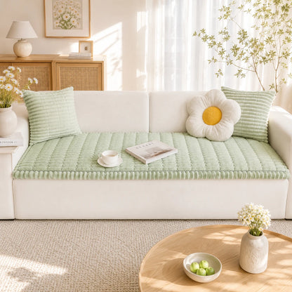 Josh & Tate - CozyLayer™ Plush Sofa Protector - Light green cushion on a white sofa with decorative items in a bright living room.