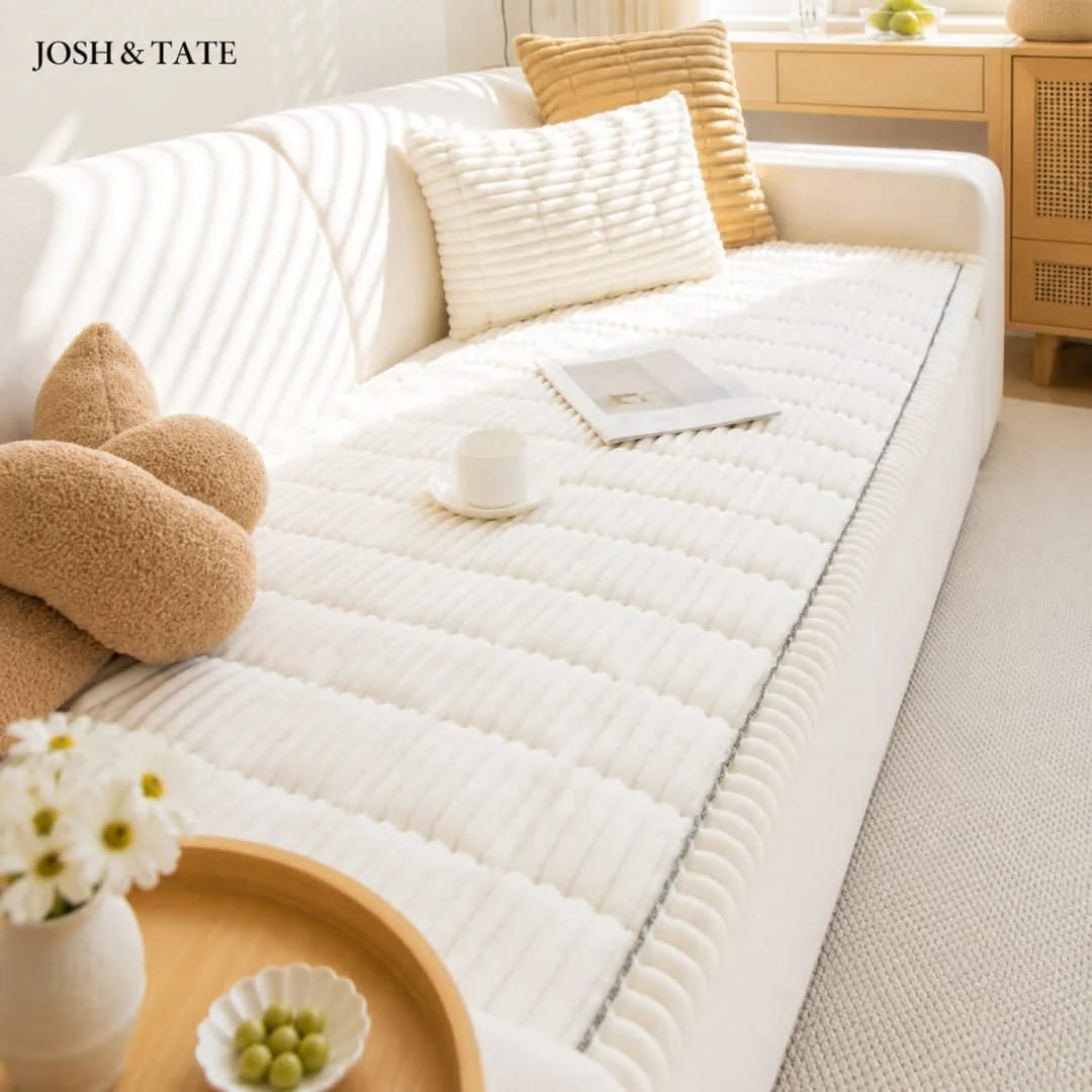 Josh & Tate - CozyLayer™ Plush Sofa Protector - White mattress cover on a bed with decorative pillows and a small table in a room.