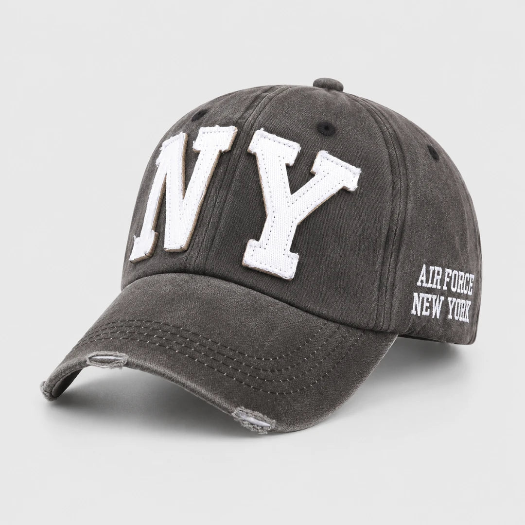 Josh & Tate - CraftWorn™ Distressed NY Cap - A dark gray washed baseball cap featuring large white embroidered 'NY' letters on the front and 'AIR FORCE NEW YORK' text on the side, shown on a light gray background.