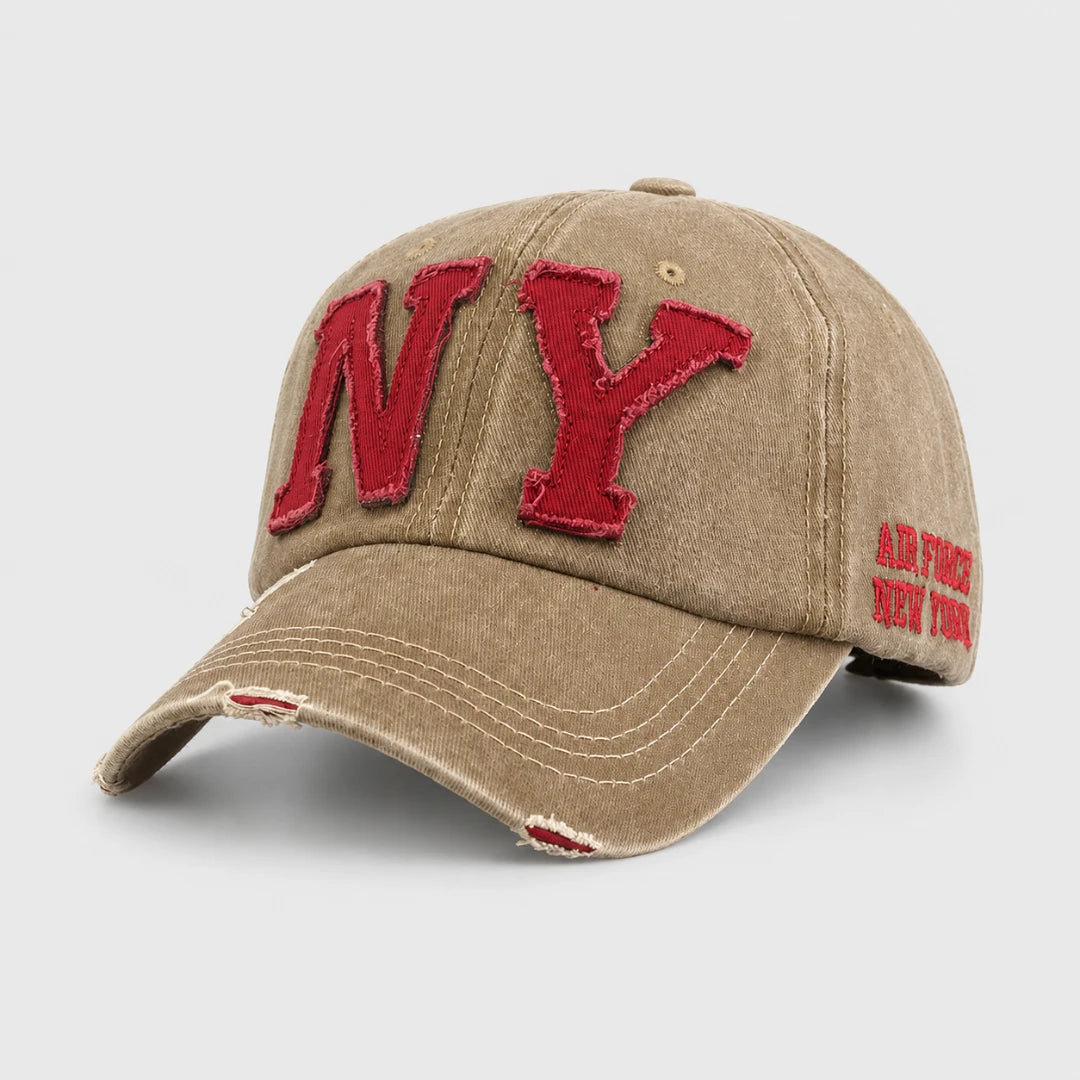 Josh & Tate - CraftWorn™ Distressed NY Cap - A distressed tan baseball cap featuring a large red embroidered 'NY' on the front and 'AIR FORCE NEW YORK' on the side, shown on a light gray background.