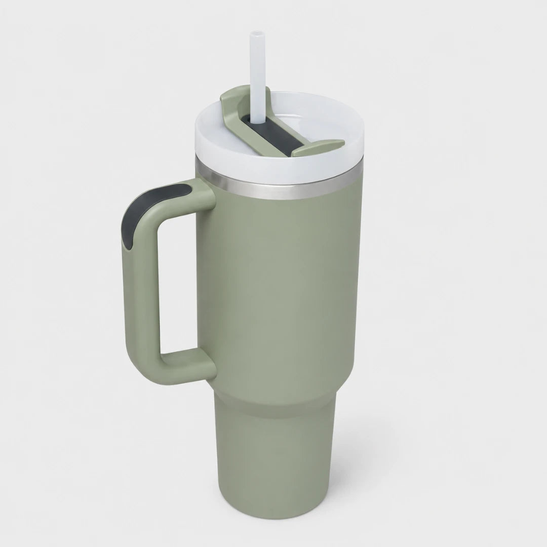 A matte sage green insulated travel tumbler with a matching handle, a white lid, and a clear straw, shown on a light gray background.