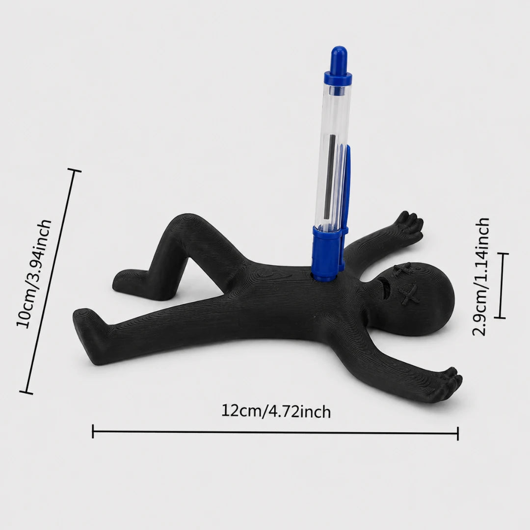 Josh & Tate - DeadDrop™ Desk Pen Stand - A black figurine-shaped desk stand holding a blue and clear pen, shown on a light gray background with dimension lines and text indicating 12cm width, 10cm height, and 2.9cm pen height.