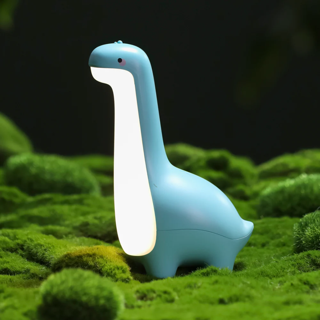 Blue dinosaur-shaped lamp on a grassy surface with a dark background