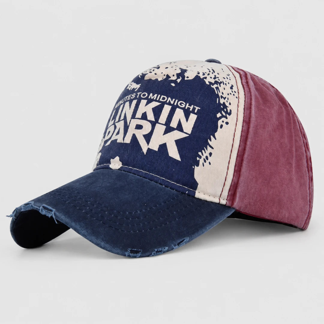 Josh & Tate - DistressedCap™ Embroidered Baseball Cap - A distressed baseball cap featuring a navy blue front panel with white text reading 'Takes to Midnight Blinkin' Park,' a cream side panel with a distressed graphic, and a burgundy side panel, shown on a light gray background.