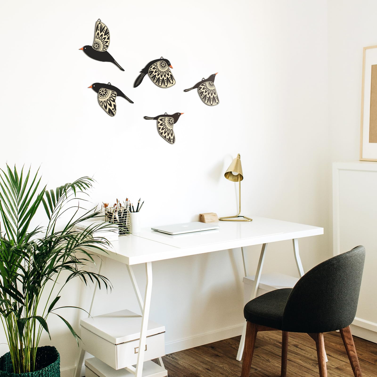 Modern office setup with white desk, black chair, and decorative bird wall art.