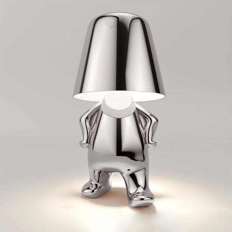 Chromed lamp shaped like a person on a light gray background