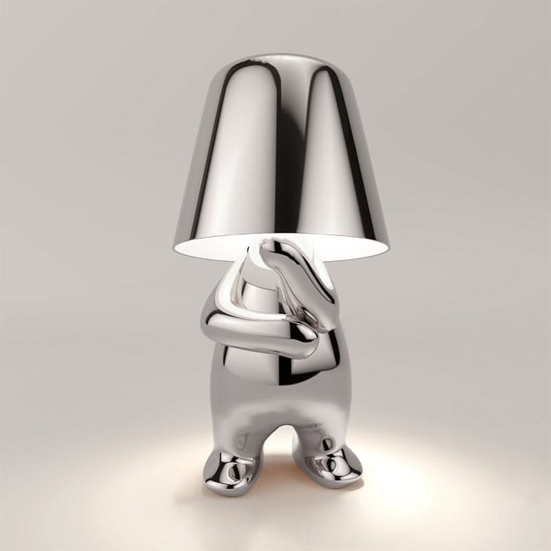 Silver character-shaped lamp on a light gray background