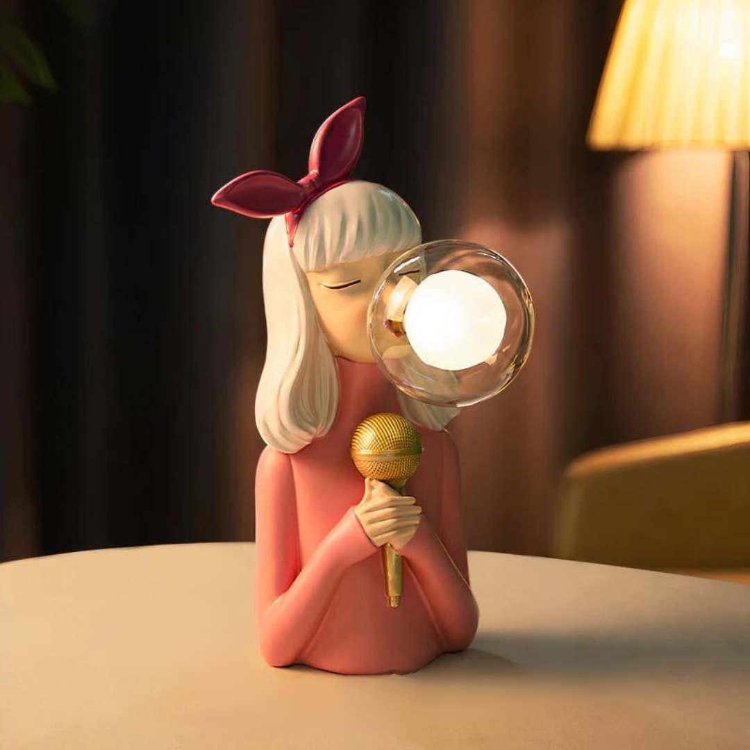 Decorative lamp shaped like a girl with a microphone and light bulb on a table.
