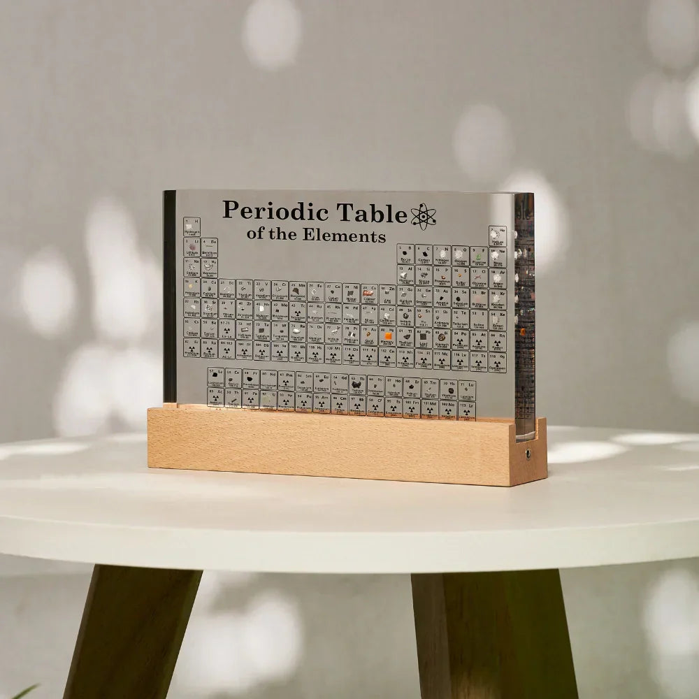 Periodic Table of Elements book on a wooden stand with a neutral background