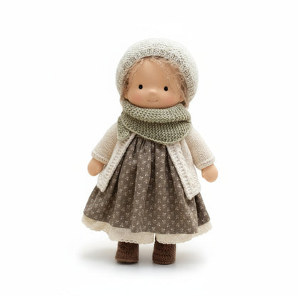 Toy doll wearing a knitted outfit on a white background