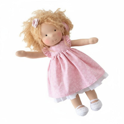 Doll with blonde hair and a pink dress on a white background