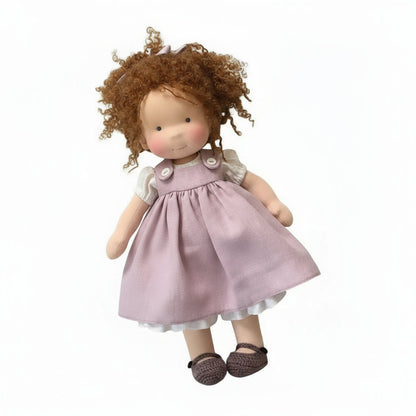 Doll with curly hair wearing a pink dress on a white background