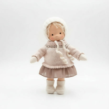 Toy doll wearing a knitted outfit on a white background