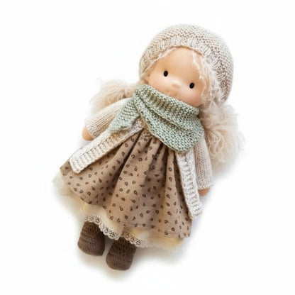 Toy doll wearing a knitted outfit on a white background