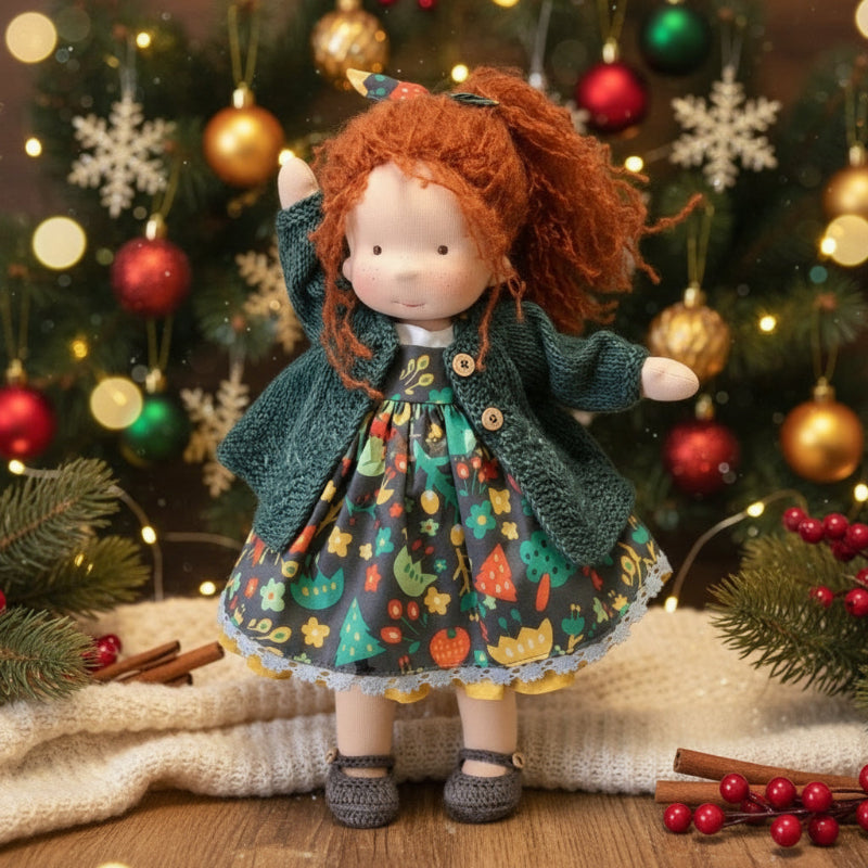 Doll with red hair and a green coat standing in front of a decorated Christmas tree.