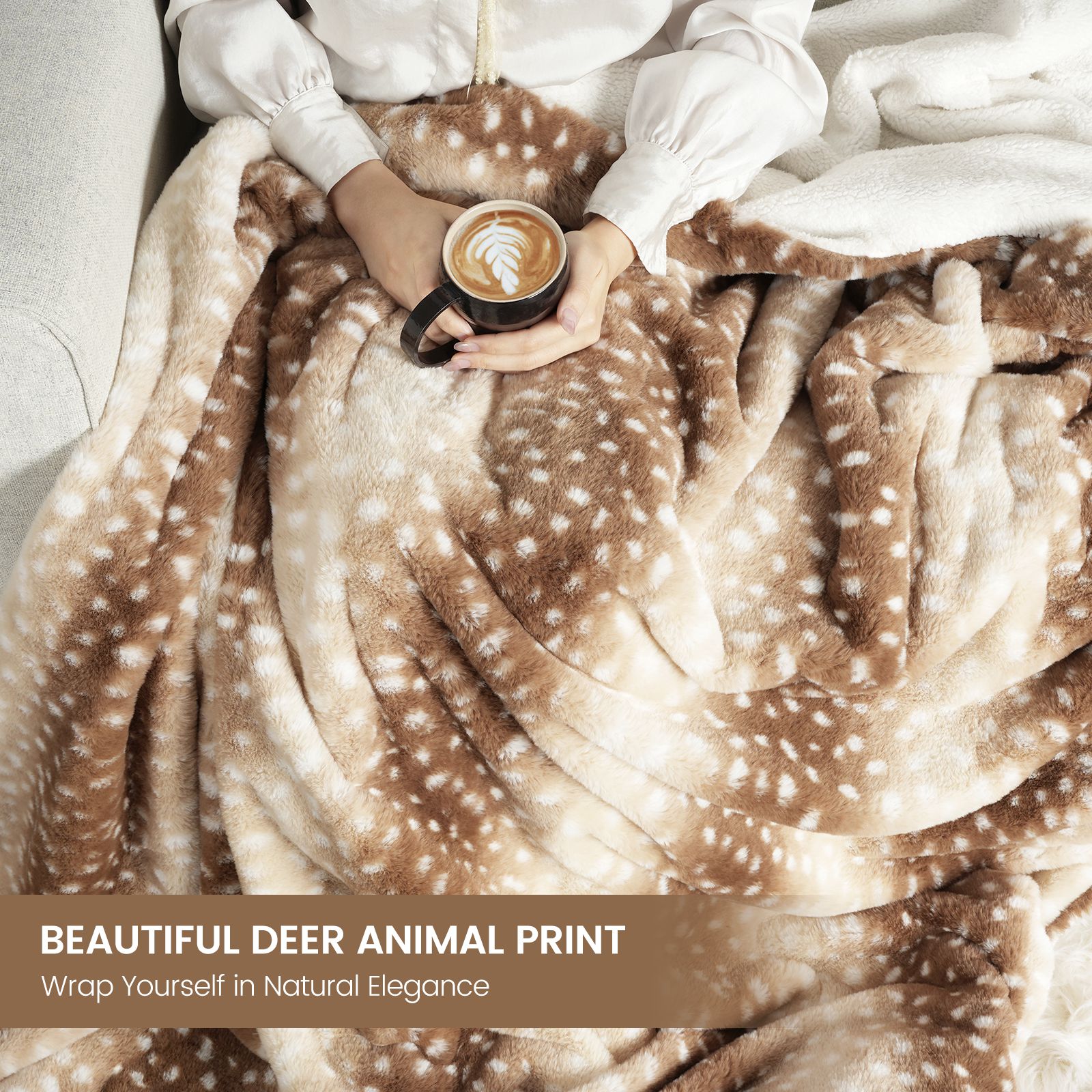 Person wrapped in a deer animal print blanket holding a coffee cup.