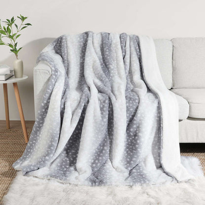 Gray and white patterned blanket draped over a sofa in a living room setting.