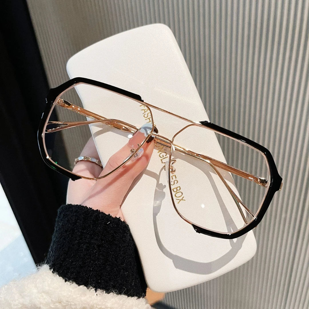Josh & Tate - FlexFrame™ Bold Frame Glasses - Hand holding a pair of gold and black sunglasses with 'Glasses Box' branding.