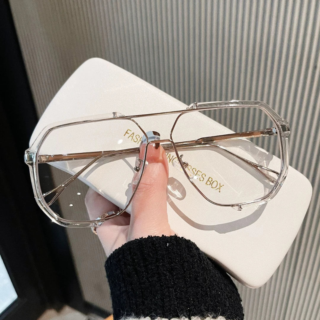 Josh & Tate - FlexFrame™ Bold Frame Glasses - Clear sunglasses held by a hand with a branded box in the background