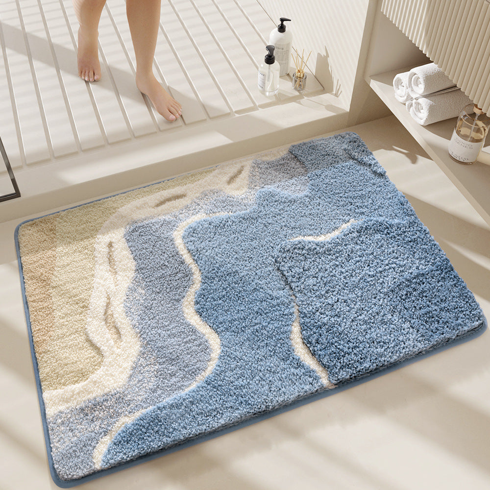 Blue and beige textured bath mat on a bathroom floor with a window in the background.
