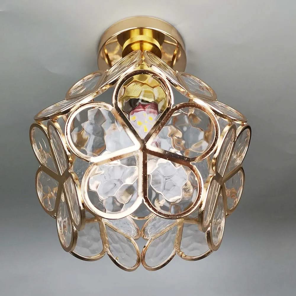 Decorative ceiling light fixture with gold and clear design on a gray background