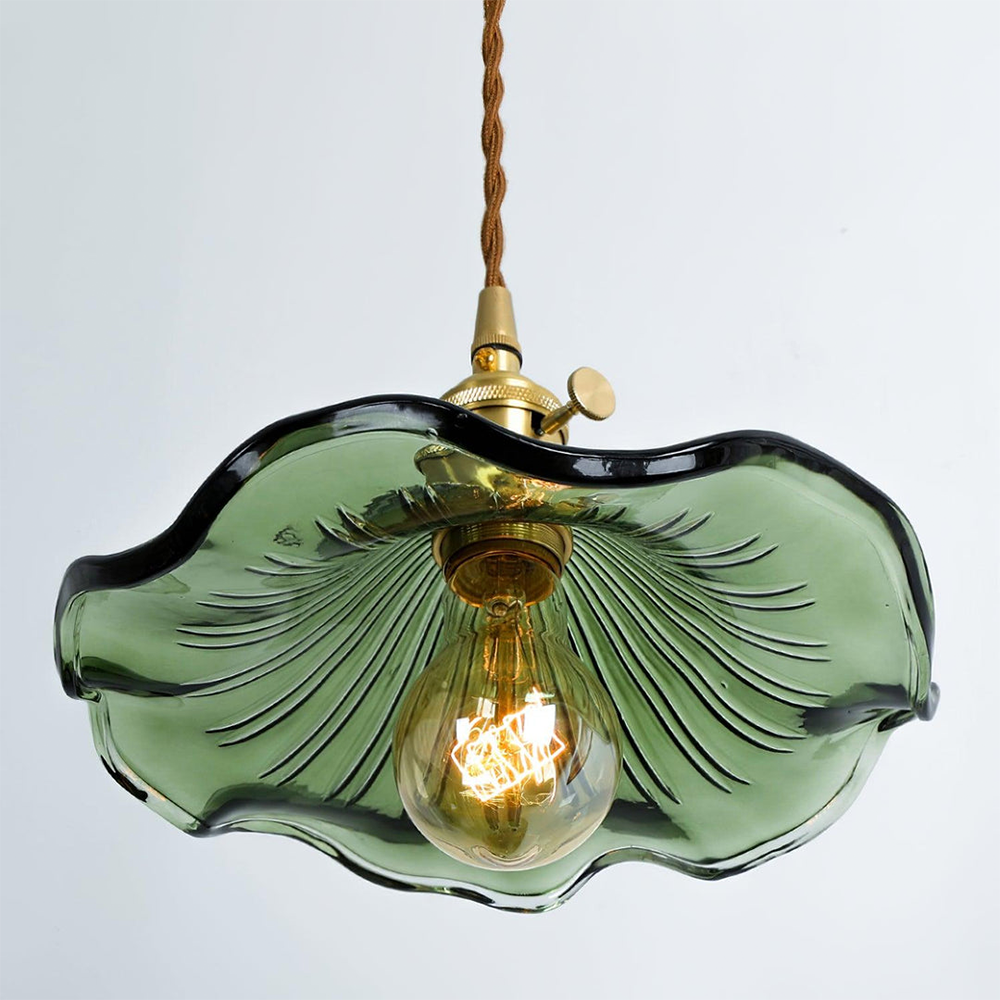 Green glass pendant light with a gold bulb on a white background